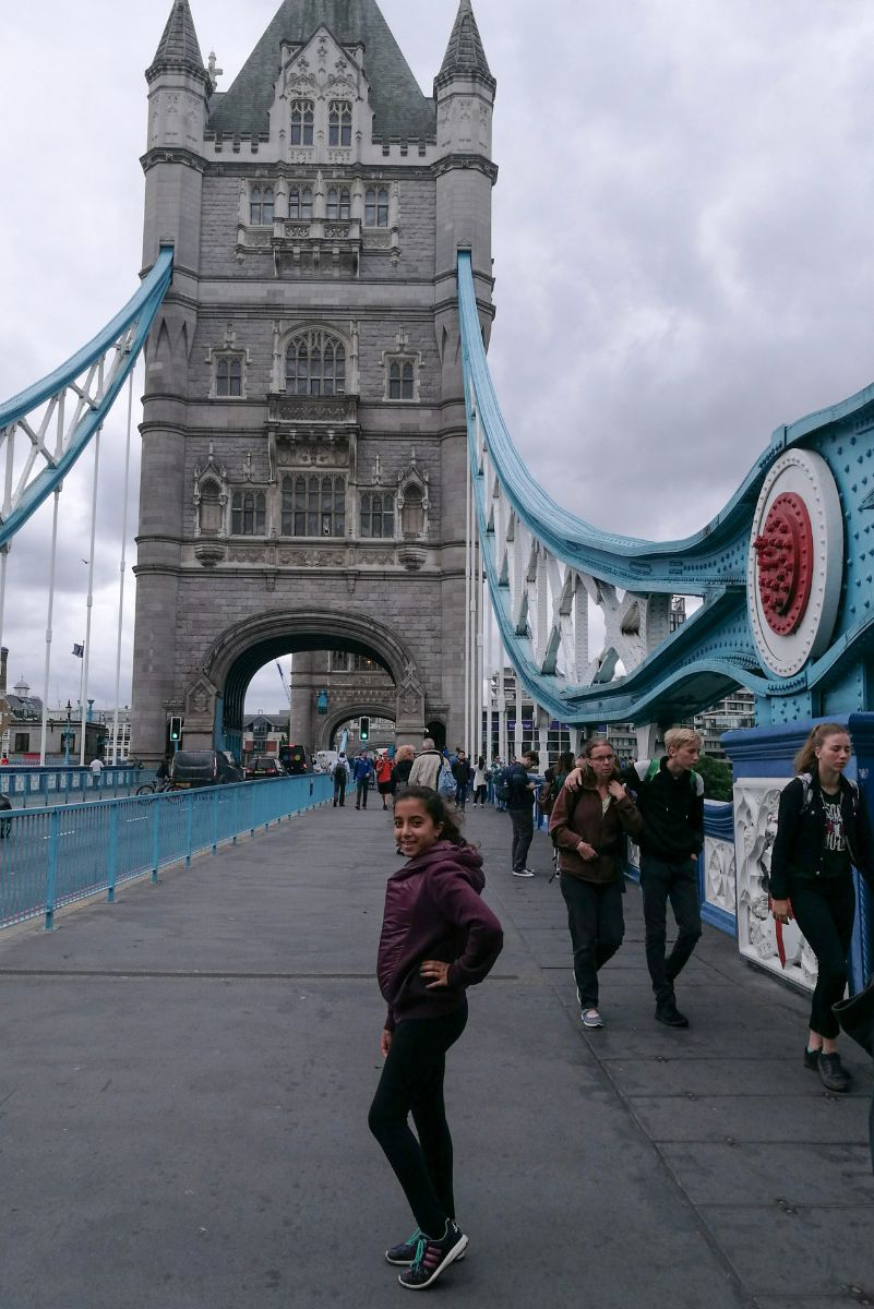 שירה עומדת על המדרכה של גשר הטאוור הכחול והלבן בלונדון