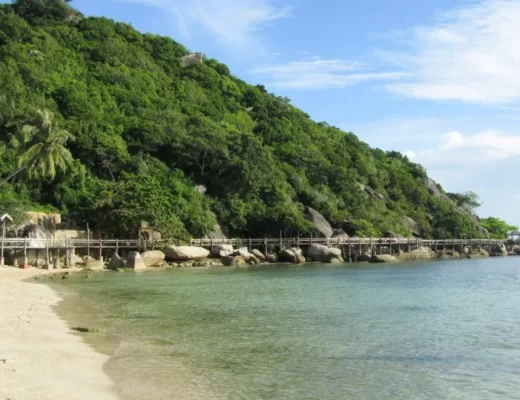 גשר עץ על סלעים לאורך קו החוף בקופנגן, תאילנד - מסלול הליכה בחוף לילה